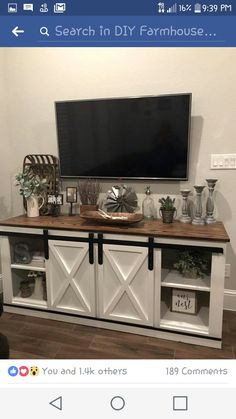 a tv on top of a white entertainment center with sliding doors in front of it