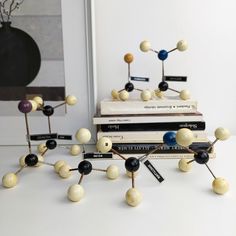 a stack of books sitting next to each other on top of a white table covered in magnets