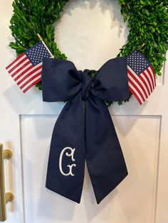 a wreath with an american flag and the letter c on it hangs on a door