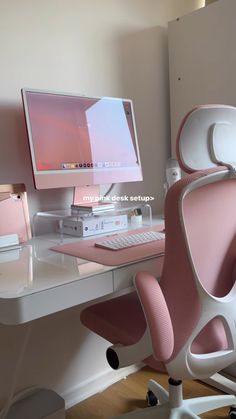 a computer desk with a pink chair next to it and a monitor on the table