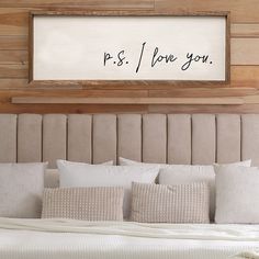 a bed that has pillows on it and a framed sign above the headboard saying, k s i love you