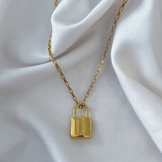 "Look absolutely stylish with this waterproof lock pendant necklace! With its low-key charm, it's perfect for layering with all your other Aviessa pieces. ♡︎ 𝘼 𝙥𝙤𝙧𝙩𝙞𝙤𝙣 𝙤𝙛 𝙥𝙧𝙤𝙛𝙞𝙩𝙨 𝙛𝙧𝙤𝙢 𝙚𝙫𝙚𝙧𝙮 𝙤𝙧𝙙𝙚𝙧 𝙞𝙨 𝙙𝙤𝙣𝙖𝙩𝙚𝙙 𝙩𝙤 𝙒𝙤𝙢𝙚𝙣 𝙞𝙣 𝙣𝙚𝙚𝙙 ♡︎ ꕥ 𝗢𝗨𝗥 𝗝𝗘𝗪𝗘𝗟𝗥𝗬 𝗜𝗦 ꕥ * High Quality * Handmade * Waterproof  * 100% Lead & Nickel Free  * Won't tarnish or discolour * Hypoallergenic * Recyclable ꕥ 𝗠𝗔𝗧𝗘𝗥𝗜𝗔𝗟𝗦 ꕥ * 18K Gold Plated PVD Stainless Steel * Gold Lock Necklace As Gift, Gold Chain Necklace With Lock For Gift, Yellow Gold Necklace With Lock As Gift, Padlock Necklace, Lock Pendant, Box Chain Necklace, Lock Necklace, Necklace Layering, Recyclable Packaging