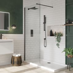 a bathroom with green walls and white tiles on the floor, along with a walk in shower