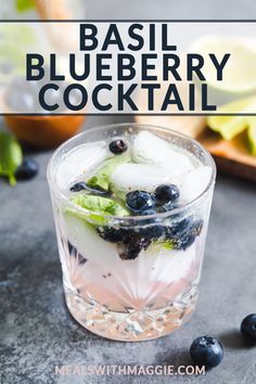 basil blueberry cocktail in a glass with ice and mint garnish on the side