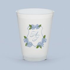 a white cup with blue flowers and the letter g on it's side is shown