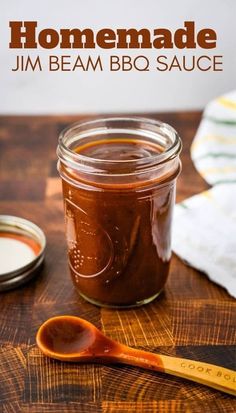 homemade jam with bbq sauce in a jar on a wooden table next to a spoon