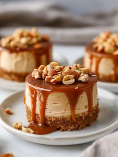 three desserts with nuts and caramel drizzled on them sitting on white plates