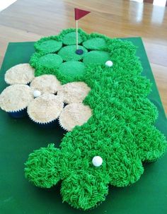 a cake made to look like a golf course with cupcakes in the grass