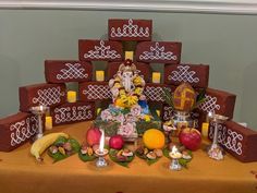 there is a gandap made out of bricks and fruit on the table with candles