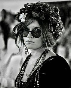 a woman wearing sunglasses and a flower in her hair