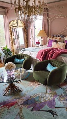 a bedroom decorated in pink and green with peacocks on the bed, chandelier