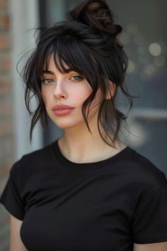 Woman with dark hair in a bun wearing a black t-shirt and looking directly at the camera. Wispy Grunge Bangs, Thick Wavy Hair With Curtain Bangs, Wavy Ponytail With Bangs, Wavy Hair Bangs Hairstyles, Thick Hair Styles Women, Long Wavy Bangs, Medium Length Goth Hairstyles, Wavy Fringe Hairstyles, Bangs For Long Wavy Hair