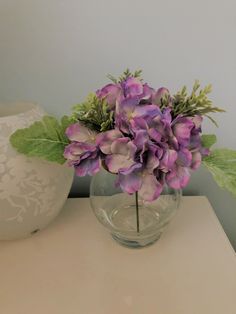 there is a vase with purple flowers in it