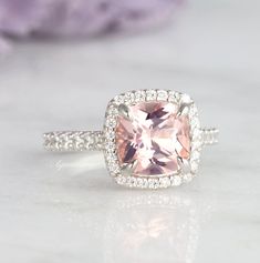 Beautiful Classic Cushion Morganite Ring ►Made of solid sterling silver with rhodium finish (925) ►Accented with simulated diamonds (CZ) ►Average band width: 1.9 mm Center Stone: Morganite Color: Peachy-Pink Shape: Cushion Measurements: 8.0 x 780 mm Carat Weight: 2.4 ct. (approx.) Gemstone creation: Lab-Created ✓ 100% Nickel-Free ✓ Hypoallergenic ✓ Comfort Fit ✓ Free Ring Box ✓ Free USA Shipping ✓ Ready to ship next business day Classic Pink Halo Ring, Classic Morganite Diamond Ring For Wedding, Classic Morganite Diamond Wedding Ring, Classic Pink Halo Ring With Gemstone, Classic Morganite Cushion Cut Rings, Classic Pink Gemstone Halo Ring, Classic Morganite Solitaire Rings, Classic Morganite Ring With Round Cut, Classic Morganite Round Cut Rings