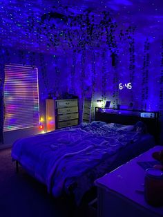 a bed room with a neatly made bed and purple lights on the wall above it