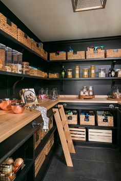 an organized pantry with wooden shelves and baskets