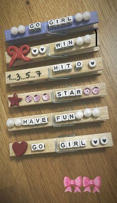 three wooden pegs with words and bows on them, each spelling out the word