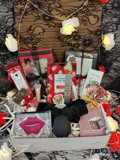 the contents of a valentine's day gift box laid out on a lace tablecloth