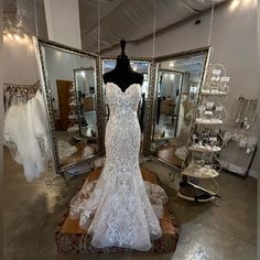 a wedding dress on display in front of mirrors