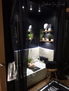 a bathroom with black walls and white tile on the floor, along with shelves filled with potted plants