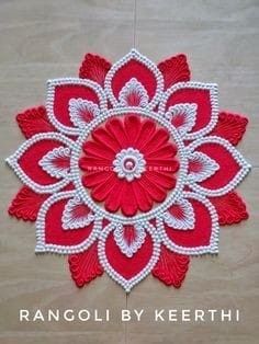 the red and white flower is made out of yarn, which has been stitched together