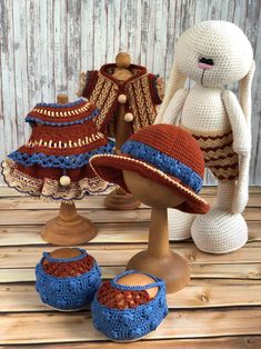 two crocheted hats and shoes are sitting on a wooden table next to a stuffed bunny