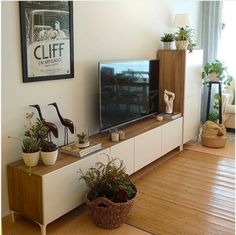 a flat screen tv sitting on top of a wooden entertainment center in a living room