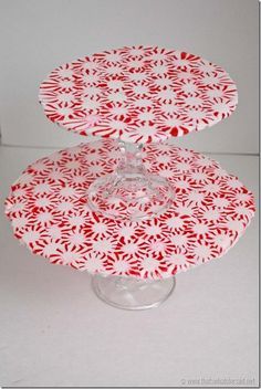 two red and white plates sitting on top of each other in front of a white background