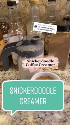 a cup of coffee sitting on top of a counter next to some bottles and spoons