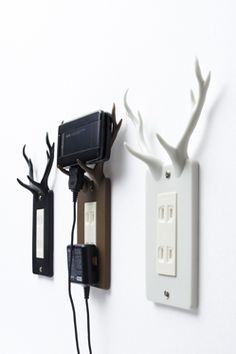 an electrical outlet with two deer antlers on it and one plugged into the wall