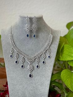 Extremely Gorgeous and Pretty White gold Plated CZ necklace with matching earrings is an elegant set for your local gatherings or parties! Measurements of the earrings: -------------------------------- Height of the earrings: 6.5 cm Width: 2 cm Care Instruction : Avoid Heat & Chemicals Like Perfume, Deo, Alchol, Etc. | Clean With Dry Cotton Cloth | Pack In our Anti tarnish box after use. White Necklace Set, Cubic Zirconia Jeweled Jewelry Sets For Celebration, Cubic Zirconia Jewels Jewelry Sets For Celebration, Cubic Zirconia Jewelry Sets For Celebration, Hand Set Cubic Zirconia Dangle Necklaces, Handcrafted Cubic Zirconia Dangle Necklaces, Cubic Zirconia Dangle Bridal Necklace For Party, Crystal Jewelry Sets For Celebration, Silver Jewelry Sets With Matching Earrings For Reception