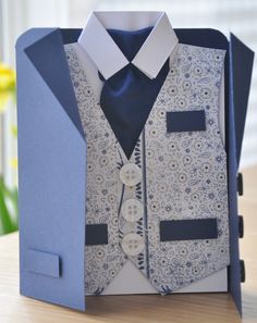 an origami card with a suit and tie in it's box on a table