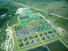 an aerial view of a large field with water and land cover in the foreground