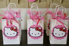 three hello kitty bags with pink bows on them