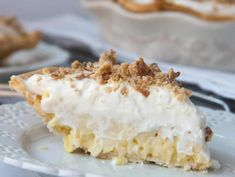 a piece of pie sitting on top of a white plate next to another pie in the background