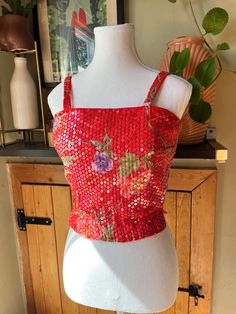 This dazzling Midcentury crop top is vibrantly coloured with a pretty floral pattern. It is covered in iridescent sequins to add sparkle and shine to your outfit while having a tropical feel. The top has spaghetti straps, a fitted waist, and zips up the back with a metal zipper.  Label: Helen H. Halpern Size: none indicated but fits like an extra small (no stretch to fabric except waistband) Measurements (taken flat): Pit to pit - 16.5" Waist - 12" to 13" stretched Shoulder to hem - 17" Pit to h Red Fitted Top For Party Season, Multicolor Sequined Crop Top, Multicolor Sequin Crop Top, Red Summer Evening Crop Top, Retro Sleeveless Party Top, Festive Fitted Glamorous Crop Top, Glamorous Summer Festive Crop Top, Glamorous Fitted Crop Top For Festive Season, Fitted Glamorous Crop Top For Festive Season