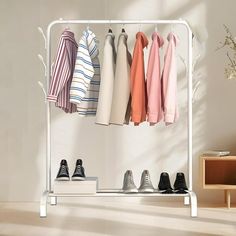 a rack with shoes and shirts hanging from it's sides in front of a white wall