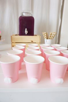 pink cups are lined up on a table