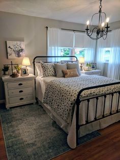 a bed room with a neatly made bed and a chandelier