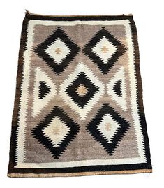 an old rug with black and white designs on it's sides, sitting on a white surface