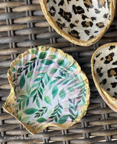 three leopard print plates sitting on top of a wicker table