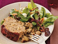 a white plate topped with meat and salad