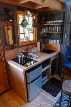 a kitchen with a stove top oven sitting next to a sink under a window in a house