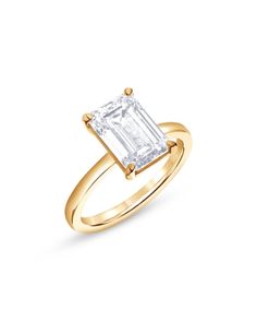 a yellow gold ring with an emerald cut diamond