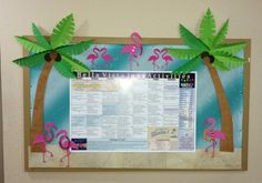 a bulletin board with palm trees and pink flamingos on the front, hanging from a wall