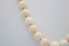 This is an incredible necklace made of Angel skin coral shell. Mostly white in color with some minor coral/pinkish tones. The beads are graduated with the center being the largest at approx 12 mm (see photo). Condition; Good vintage condition, no chips or visible damage. Clasp has a heavy patina due to age. Size; The largest bead is about 12mm, the next size down is about 10mm and the length of the necklace is approximately 22 inches long. Hallmarks; Clasp is sterling silver (tested) but there i Elegant Hand-strung Coral Necklaces, Elegant Coral Hand-strung Necklaces, Elegant Hand-strung Coral Necklace, Elegant Cream Necklaces With Large Beads, Elegant Single Strand Coral Beads, Elegant Coral Beaded Necklaces With Large Beads, Elegant Coral Necklaces With Large Beads, Elegant Peach Necklaces With Round Beads, Elegant Peach Round Beads Necklaces