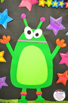 a bulletin board with a green frog holding stars in the air and writing on it