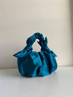 Satin small bag is crafted from smooth silk-satin. Handmade ocean bag is soft, but keeps its shape, closes with a magnetic button. Furoshiki bag is made in vintage style, based on the Japanese technigue of tying a silk scarf in a knot. Japanese knot bag is able to decorate not only official event, but also becomes a companion for every day. There are three versions of satin evening bag: -mini Height 15cm Width 25cm Handle drop 20cm -small Height 20cm Width 30cm Handle drop 25cm -big Height 25cm Chic Silk Bag For Events, Elegant Blue Gift Bag, Chic Satin Clutch Bag, Chic Satin Bags With Satin Finish, Satin Bags With Satin Finish For Events, Tying A Silk Scarf, Wedding Guest Bag, Furoshiki Bag, Ocean Bag