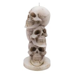 three skulls stacked on top of each other in the shape of a candle with a white background