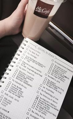 a person holding a drink next to a checklist